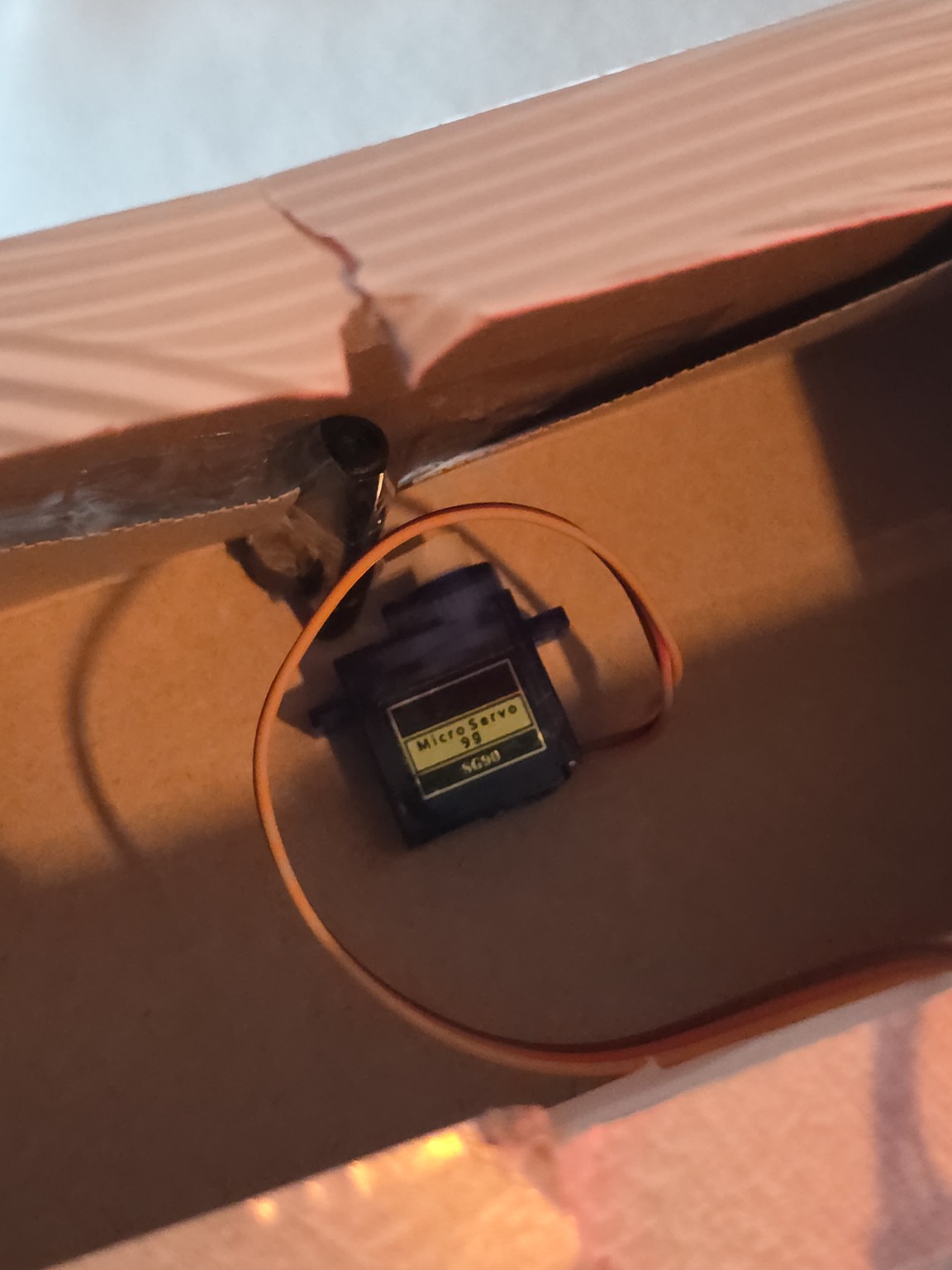 Servo in locked position blocking the cardboard latch