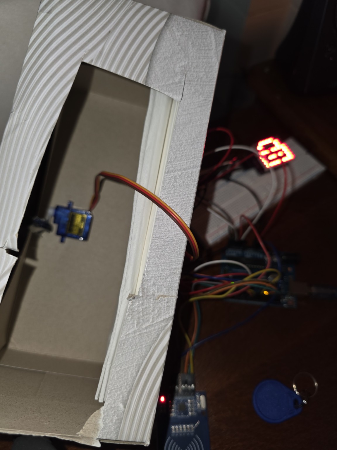 Overview of RFID lock box prototype with electronics and cardboard enclosure